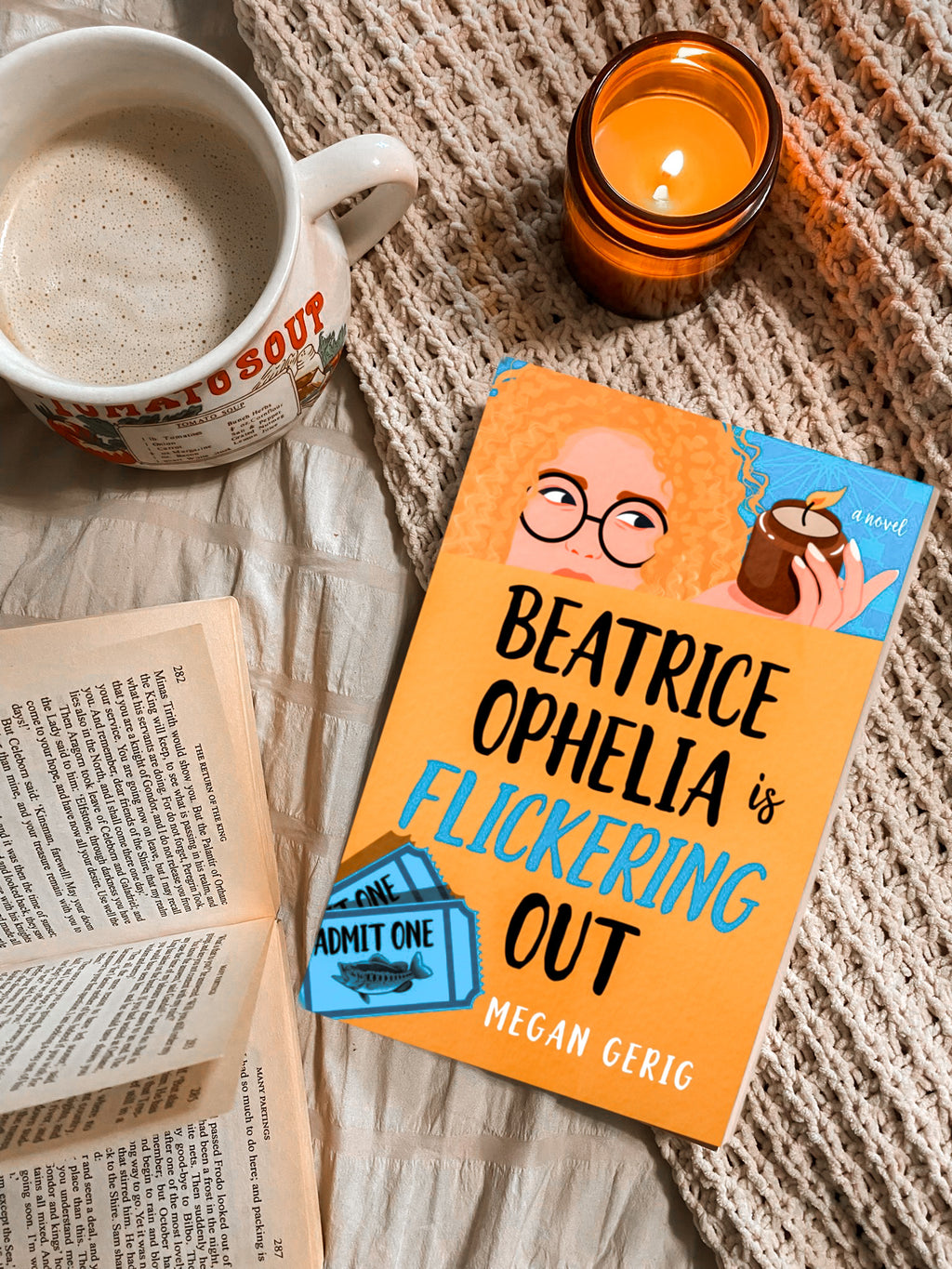 Book titled 'Beatrice Ophelia is Flickering Out' by Megan Gerig with a cup of coffee and candle on a textured surface.